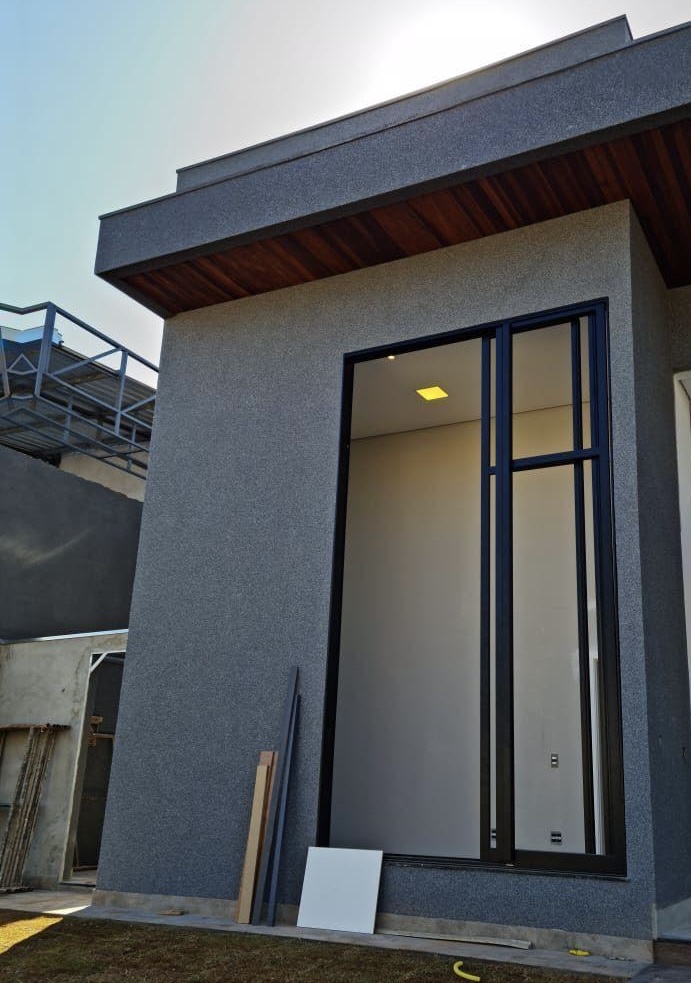 Fachada residencial cinza revestida com pedras naturais