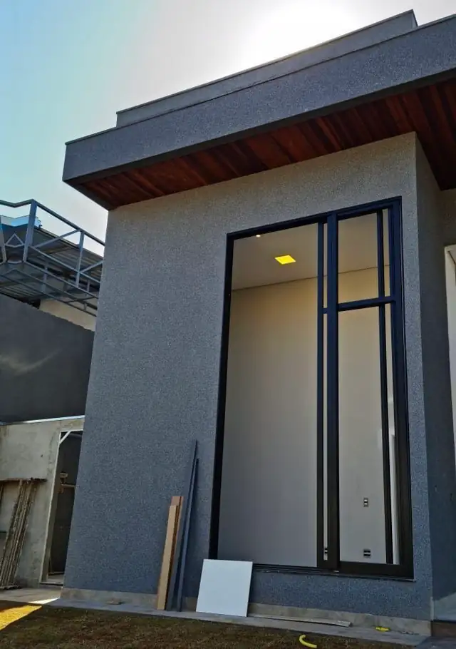 Fachada residencial contemporânea revestida em pedras naturais cinza