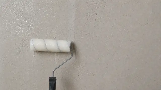 Rolo aplicando fundo preparador em parede